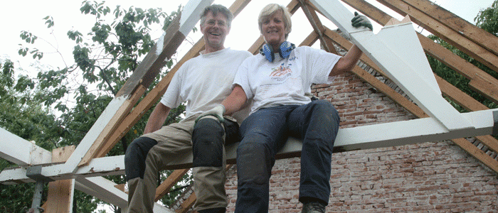 Robert en Pauline Gombault in de nok van hun boerderij, na het verwijderen van het dakbeschot, 2015